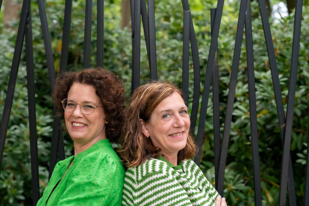 Vriendelijke vrouwen in groene kleding, professioneel advies en begeleiding door Van de Ven & Meijer Advies B.V., experts in financiële en zakelijke dienstverlening, voor optimale oplossingen en groei.